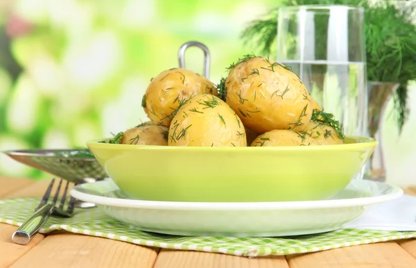 Boiled potatoes on platens on on napkins on wooden table on window background — Stock Photo, Image