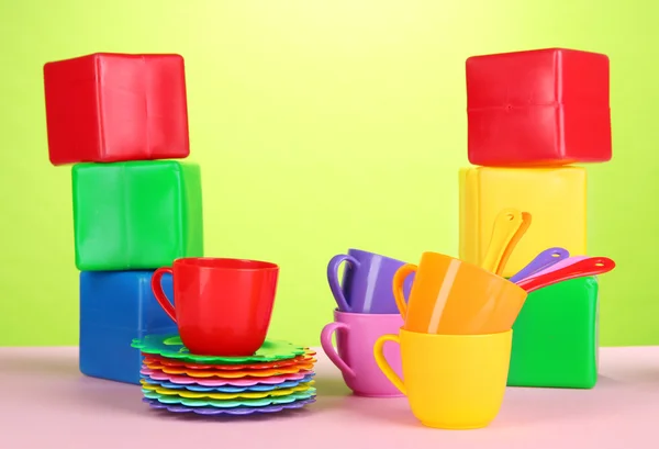 Набор детских блюд и кубиков на столе на светлом зеленом фоне — стоковое фото