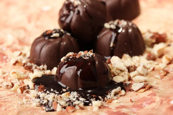 Шоколадні цукерки з горіхами на кольоровому фоні — стокове фото