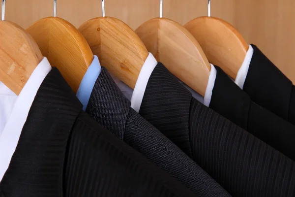 Pakken met shirts op hangers op houten achtergrond — Stockfoto