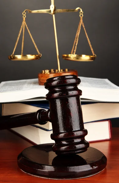 Wooden gavel, golden scales of justice and books on grey background — Stock Photo, Image