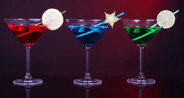 Cócteles alcohólicos en vasos de martini sobre fondo rojo oscuro —  Fotos de Stock