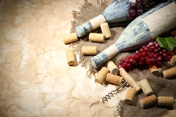 Eski şişe şarap, üzüm ve mantarlar eski kağıt arka plan üzerinde — Stok fotoğraf
