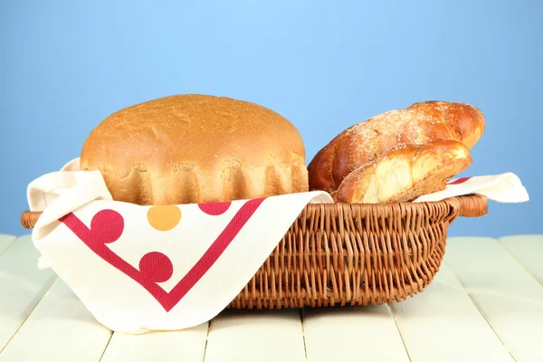 Sammansättning med bröd och rullar på träbord, på färgbakgrund — Stockfoto