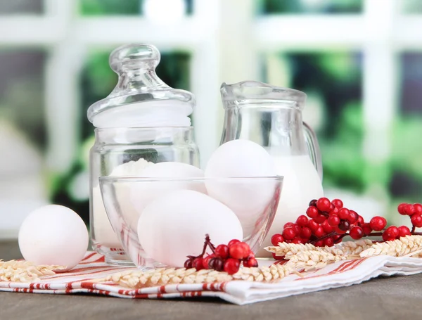 Ingrediënten voor deeg op houten tafel op achtergrond van venster — Stockfoto