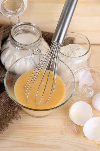 Ingredients for dough on wooden table on wooden background — Stock Photo, Image