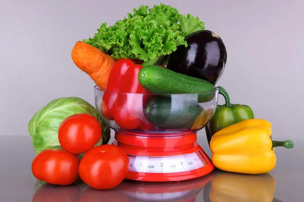 Свежие овощи в весах на сером фоне — стоковое фото