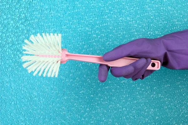 Toilet brush in hand on blue background — Stock Photo, Image