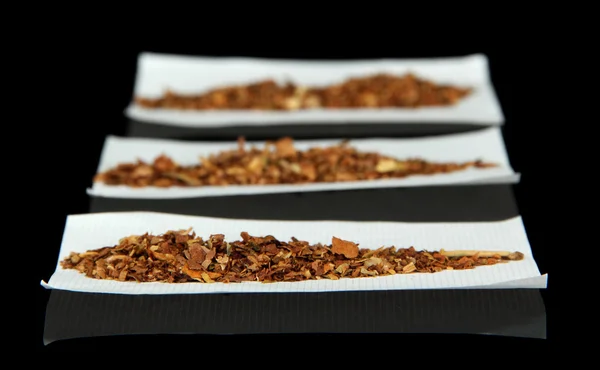 Tabaco e papel para enrolar, isolados a preto — Fotografia de Stock