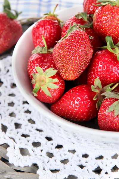 Erdbeeren im Teller auf Weidenständer auf Serviette Nahaufnahme — Stockfoto