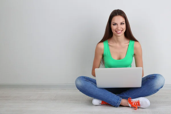 Mulher bonita sentada com laptop no quarto — Fotografia de Stock