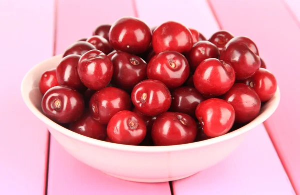 Cherry bessen in kom op houten tafel close-up — Stockfoto