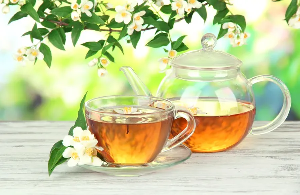 Tazza di tè con gelsomino, su tavolo di legno, su sfondo luminoso — Foto Stock