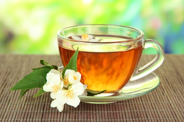 Φλιτζάνι τσάι με γιασεμί, σε χαλί μπαμπού, σε φωτεινό φόντο — Φωτογραφία Αρχείου