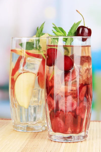 Vasos de bebidas de frutas con cubitos de hielo en la mesa en la cafetería — Foto de Stock