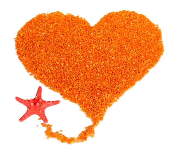 Heart of orange crystals of sea salt on grey background — Stock Photo, Image