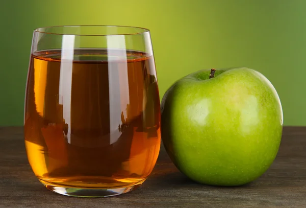Стакан свежего яблочного сока на зеленом фоне — стоковое фото