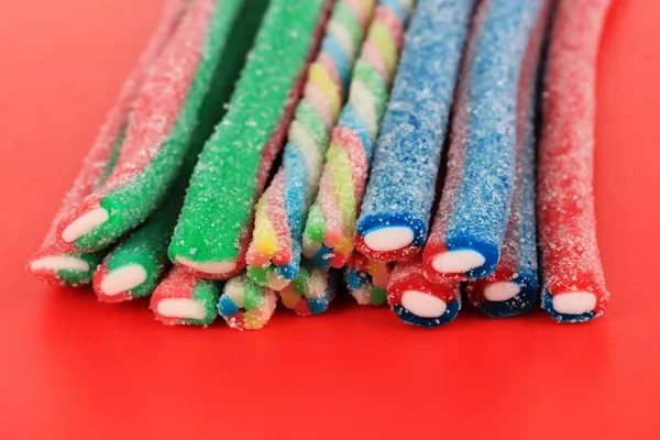 Dolci caramelle gelatina sul backgroun rosso — Foto Stock