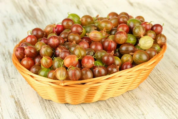 Verse kruisbessen in rieten mand op tabel close-up — Stockfoto