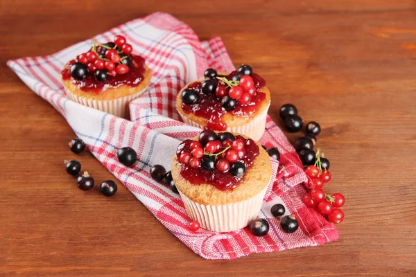 Smakelijke muffins met bessen op houten tafel — Stockfoto