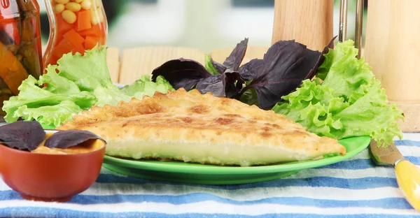 Sabrosos chebureks con hierbas frescas en el plato, en la mesa de madera, sobre fondo brillante — Foto de Stock