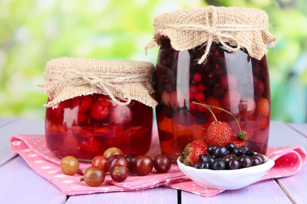 Hausgemachte Beerenmarmelade auf Holztisch auf hellem Hintergrund — Stockfoto