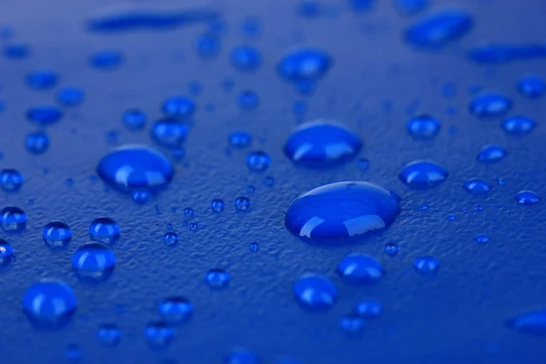 Краплі води на синьому пластиковому фоні — стокове фото