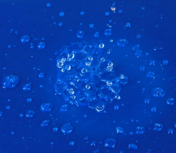 Gotas de agua sobre fondo plástico azul —  Fotos de Stock