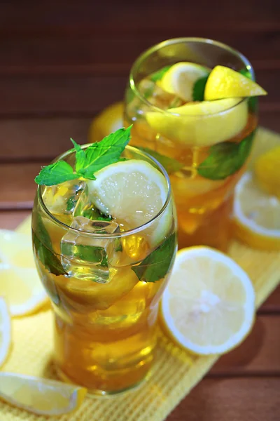 Té helado con limón y menta sobre mesa de madera —  Fotos de Stock