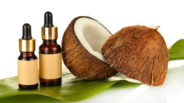 Kokosöl in Flaschen mit Kokosnüssen auf weißem Hintergrund — Stockfoto