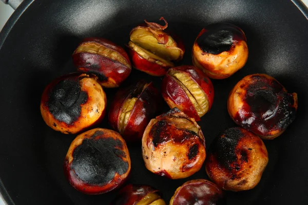 Castañas asadas en la sartén de cerca —  Fotos de Stock