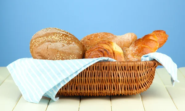 Složení s chlebem a rohlíky na dřevěný stůl, na barvu pozadí — Stock fotografie