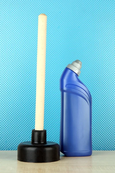 Toilet plunger and cleaner bottle on blue background — Stock Photo, Image