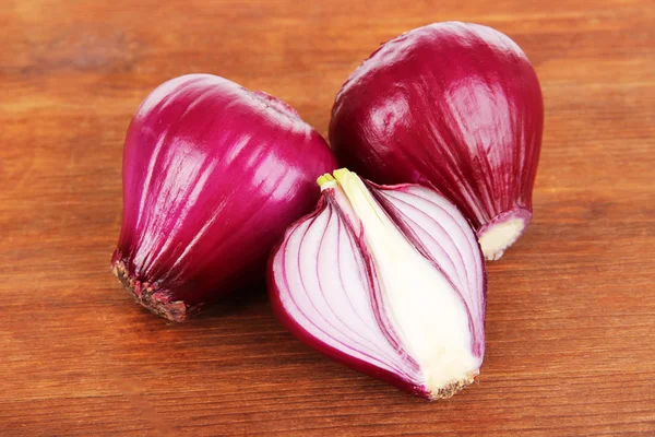 Purple onion on wooden background