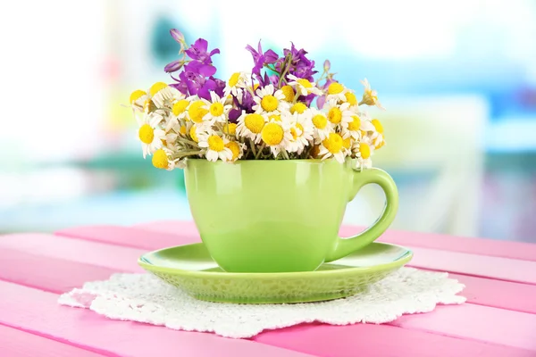 Ramillete de flores de manzanilla en copa, sobre fondo brillante — Foto de Stock