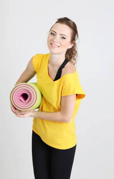 Portret van mooie jonge vrouw met gymnastiekmat — Stockfoto