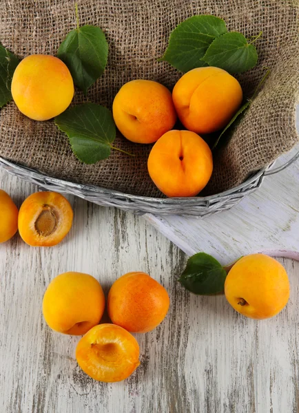 Apricots in basket on wooden table — Stock Photo, Image