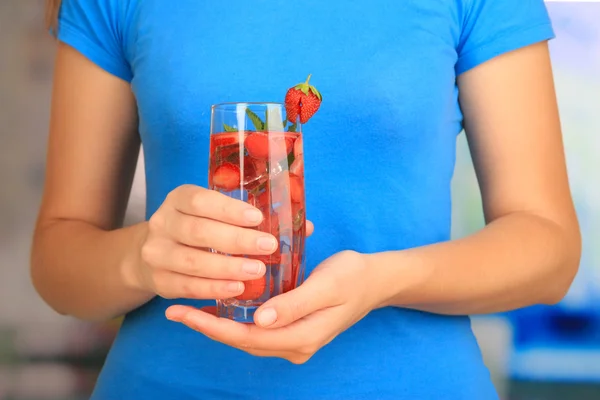 Copa de bebida de frutas con cubitos de hielo en la mano —  Fotos de Stock
