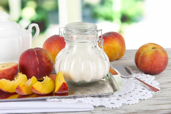 Pfirsiche mit Zucker auf Metallblech auf Serviette auf Tisch auf Fensterhintergrund — Stockfoto