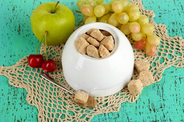 Unrefined sugar in white sugar bowl on wooden background — Stock Photo, Image