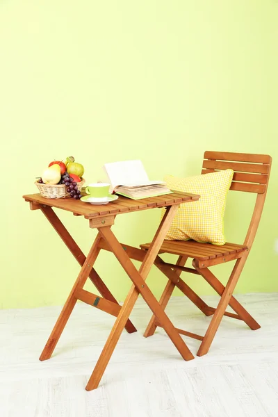 Holztisch mit Obst, Buch und Tasse auf dem Zimmer — Stockfoto
