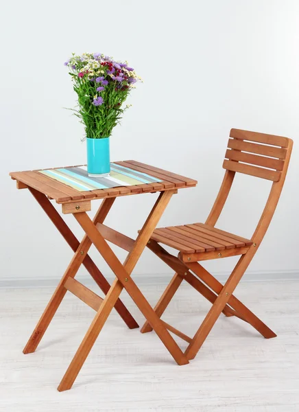 Wooden table with flower in room — Stock Photo, Image