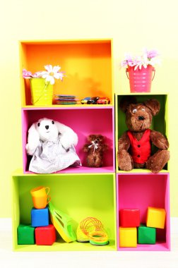 duvar arka plan üstünde toys ile farklı renkteki parlak raflar