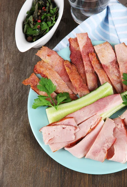 Bacon on plate on napkin on board on window table — Stock Photo, Image