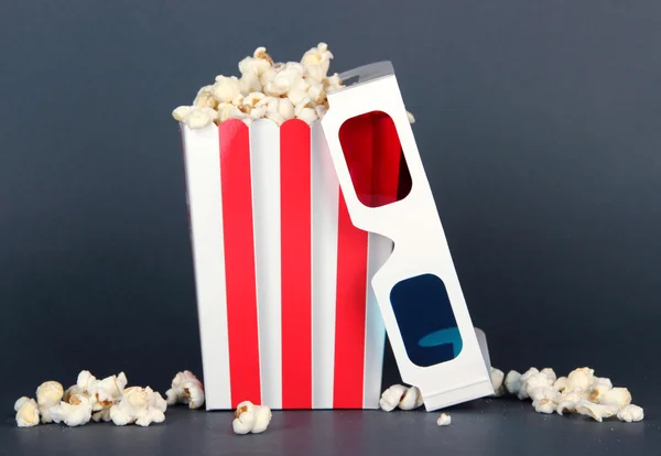 Popcorn en 3D-bril op grijze achtergrond — Stockfoto
