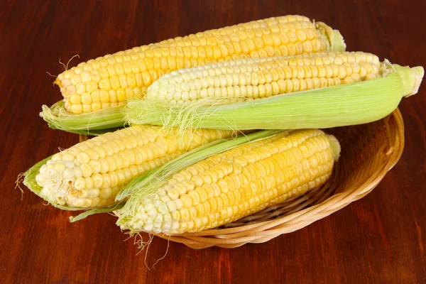 Fresh corn vegetable in wicker basket on wooden table — Stock Photo, Image