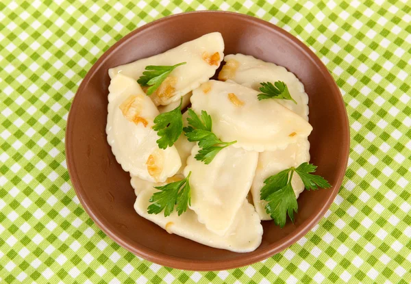 Smakelijke dumplings met gebakken UI op bruin plaat, op een achtergrond met kleur — Stockfoto
