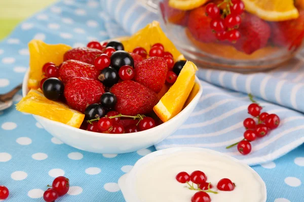 Salade de fruits utile dans une tasse en verre et un bol sur une table en bois close-up — Photo