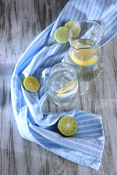 Jarra de vidrio de agua y vidrio en la mesa de madera de primer plano — Foto de Stock