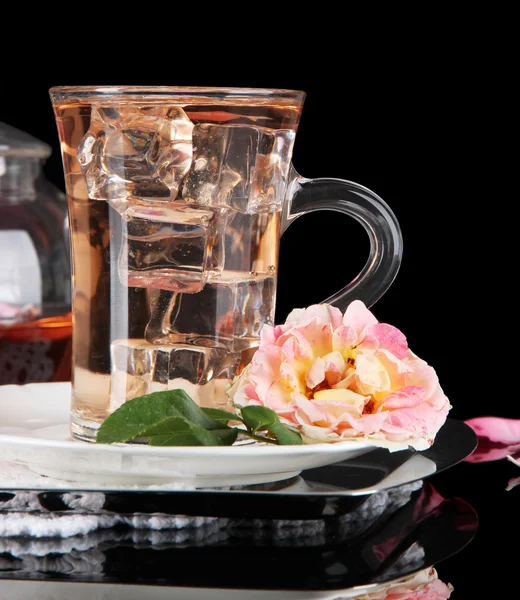 Szkło o filiżankę herbaty lód z herbaty na metalowe taca na serwetka na czarnym tle — Zdjęcie stockowe